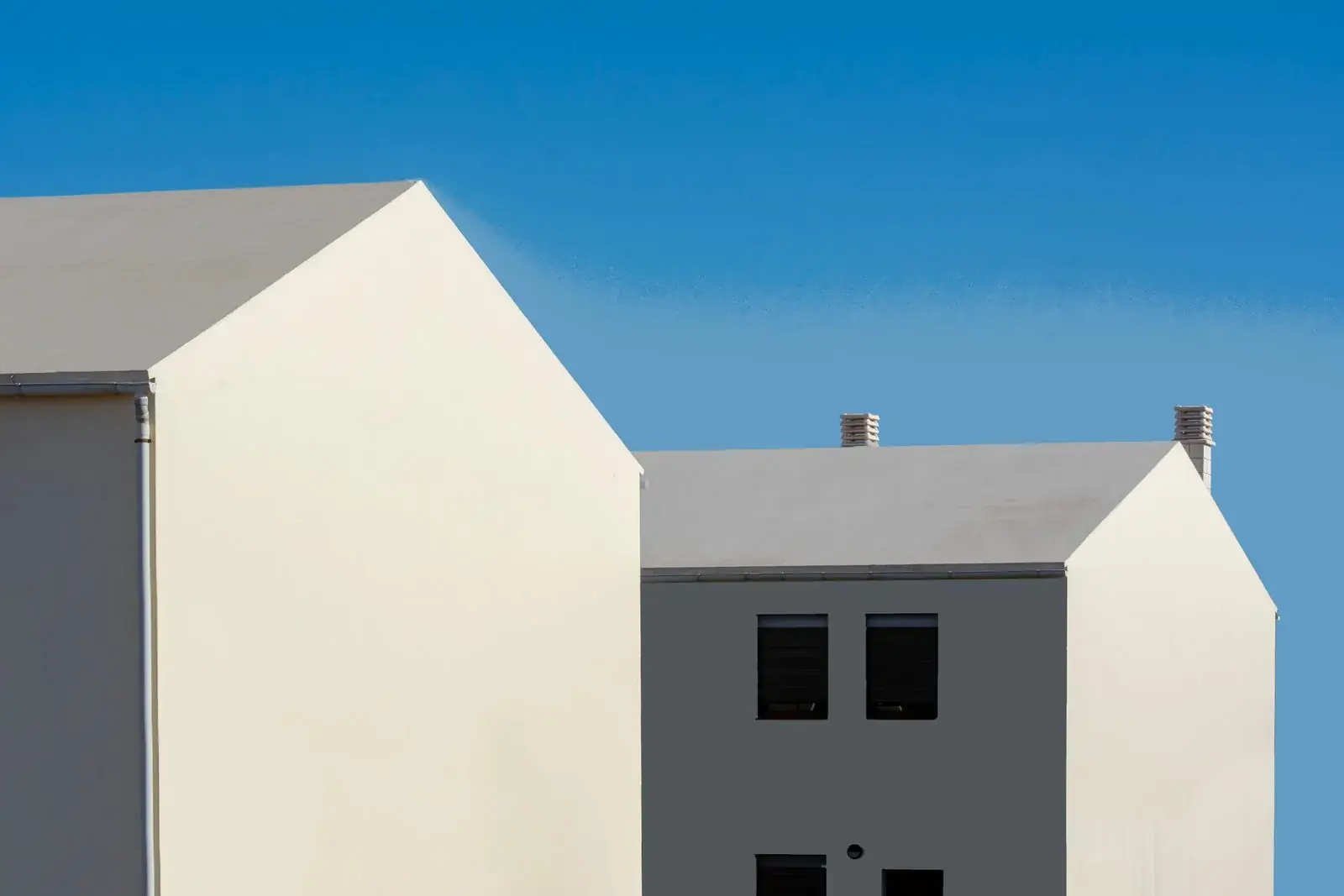 Twin white gables against a blue sky on Pell Street